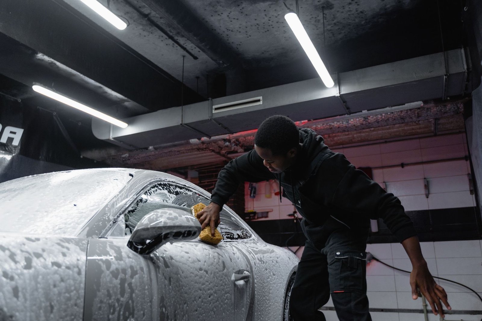 KG hand-washing a foam-covered sports car